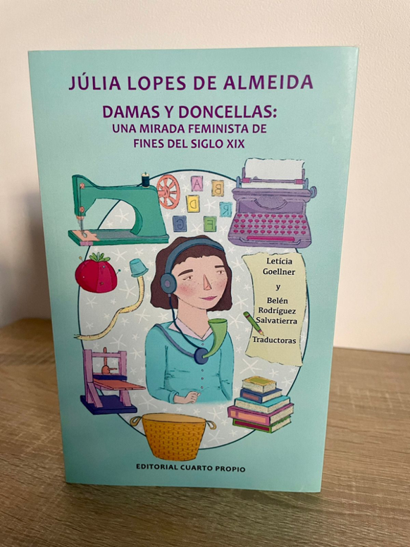 A book called Damas y doncellas  with a hand drawn cover picture showing a woman translater, a sewing machine and a typewriter