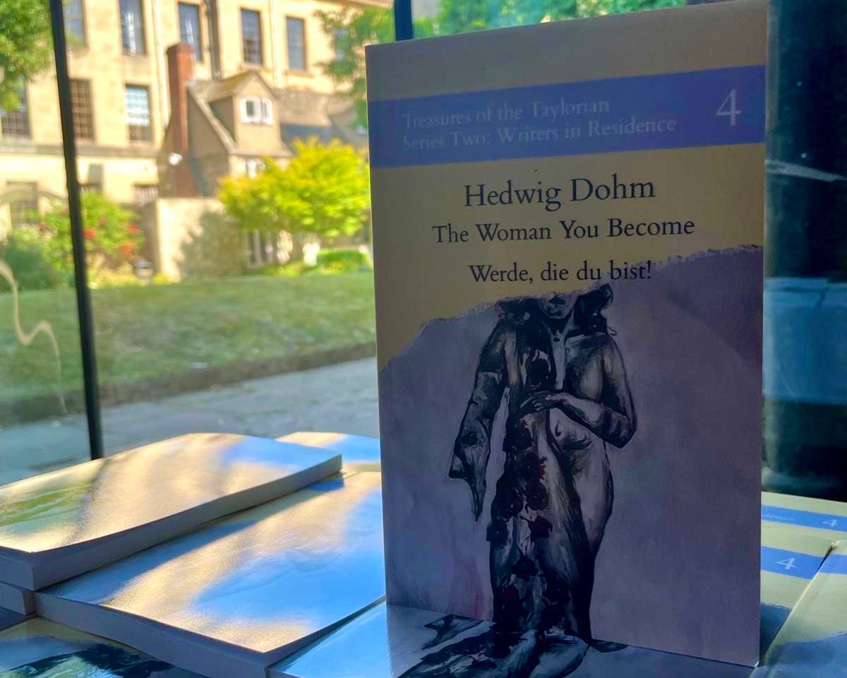 Copy of "The Woman You Become" standing upright to show the cover, with a beautiful building in the background through a window